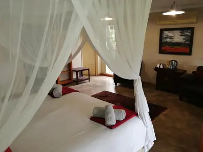 a bedroom with a bed with white curtains at Blyde Mountain Country House in Hoedspruit