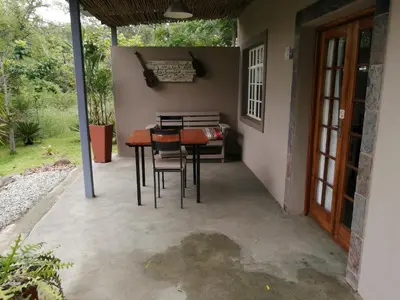 a patio with a table and chairs in a house at Blyde Mountain Country House in Hoedspruit