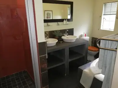 a bathroom with two sinks and a toilet at Blyde Mountain Country House in Hoedspruit
