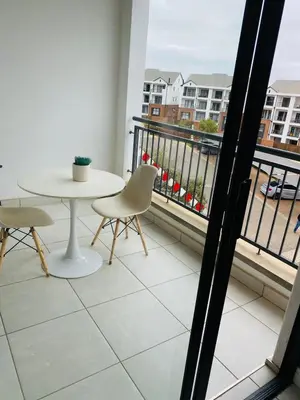 a balcony with a table and chairs and a view at Kayalako at The Blyde - Blue Crystal Lagoon in Pretoria