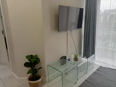 a living room with a glass table and a flat screen tv at Kayalako at The Blyde - Blue Crystal Lagoon in Pretoria