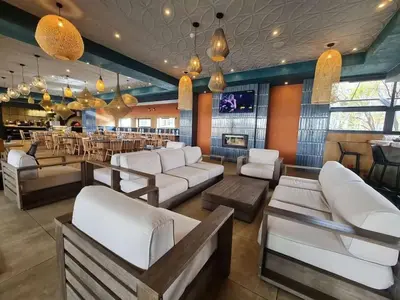 a bar with white couches and tables in a restaurant at Kayalako at The Blyde - Blue Crystal Lagoon in Pretoria
