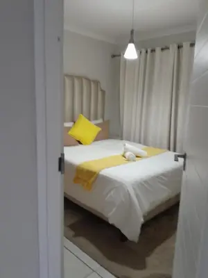 a bedroom with a large bed with a yellow pillow at Kayalako at The Blyde - Blue Crystal Lagoon in Pretoria