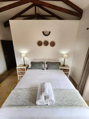 a bedroom with a white bed with a towel on it at Stella Bush Villa in Hoedspruit