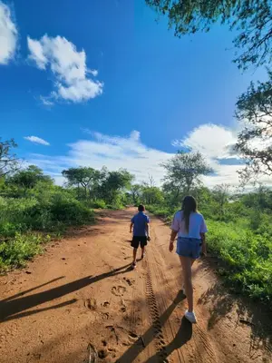 a man and a woman walking down a dirt road at Stella Bush Villa in Hoedspruit