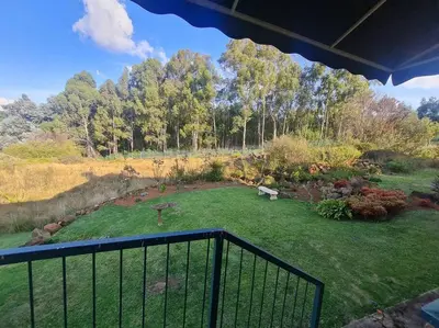 a view of a garden from a balcony at Stonefields 3 Bedroom Charmer in Dullstroom
