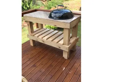 a wooden table with a grill on a deck at Stonefields 3 Bedroom Charmer in Dullstroom