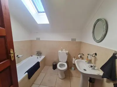 a bathroom with a tub and a toilet and a sink at Stonefields 3 Bedroom Charmer in Dullstroom