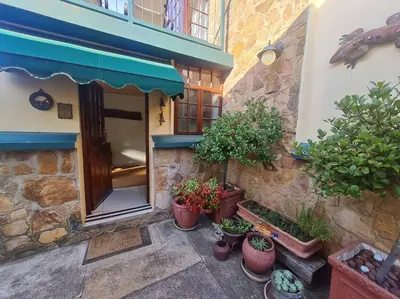 a building with potted plants in front of a door at Stonefields 3 Bedroom Charmer in Dullstroom