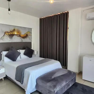 a bedroom with a large bed and a large window at Le Bamboo Guest House And Boat Cruise in Hartbeespoort