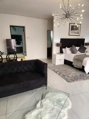 a living room with a bed and a glass table at Le Bamboo Guest House And Boat Cruise in Hartbeespoort