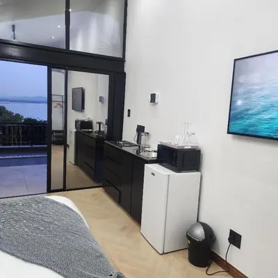 a bedroom with a white refrigerator and a tv at Le Bamboo Guest House And Boat Cruise in Hartbeespoort