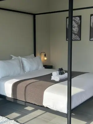 a bedroom with a large bed with a pole at SUumthing Private GuestHouse in Lebowakgomo