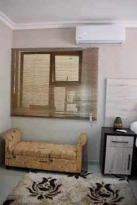 a room with a couch and a window and a table at De Guest @115 in Centurion