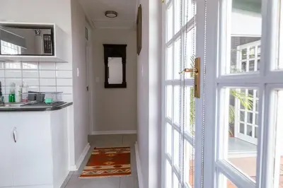 a kitchen with a door open to a kitchen with a sink at Fig Tree in Pretoria