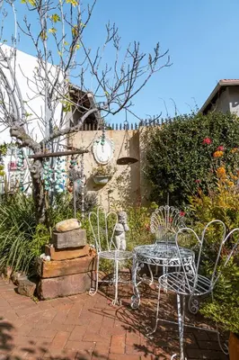 a patio with a table and chairs in a garden at Fig Tree in Pretoria