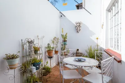 a small balcony with a table and chairs and plants at Hummingbird in Pretoria