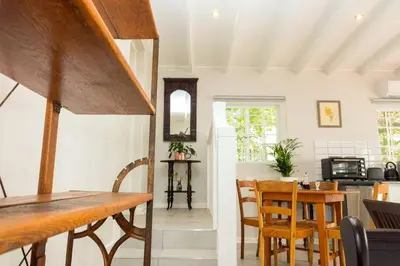 a kitchen and dining room with a table and chairs at Hummingbird in Pretoria
