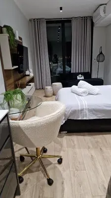 a bedroom with a bed and a glass table at Ellipse Apartment, Lush Hideaway in Midrand