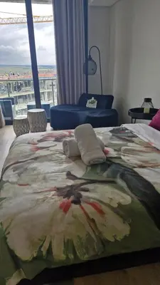 a bedroom with a bed with a painting on it at Ellipse Apartment, Lush Hideaway in Midrand
