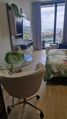 a bedroom with a bed and a glass table and a chair at Ellipse Apartment, Lush Hideaway in Midrand