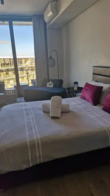 a bedroom with a large bed with two towels on it at Ellipse Apartment, Lush Hideaway in Midrand