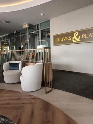 a lobby with a white chair and a sign at Ellipse Apartment, Lush Hideaway in Midrand