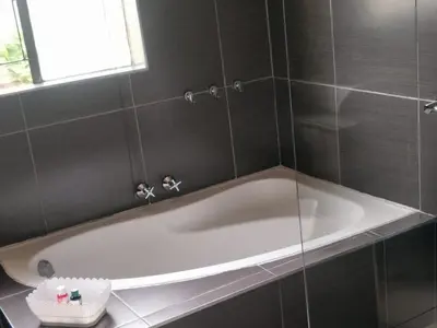 a white bath tub in a bathroom with a window at Serene B&B in Midrand
