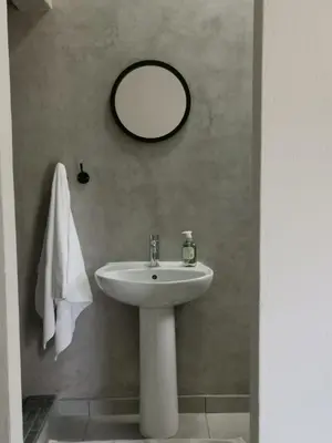 a bathroom with a white sink and a mirror at Stay@Opstal in Pretoria