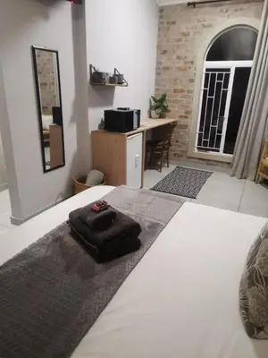 a bedroom with a bed with a black towel on it at Stay@Opstal in Pretoria