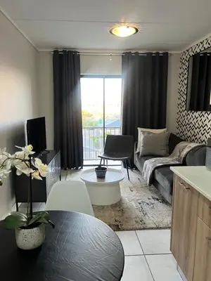 a living room with a couch and a table at The Lagoon Exquisite Apartments in Pretoria