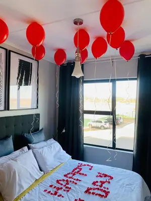 a bedroom with red balloons hanging from the ceiling at The Lagoon Exquisite Apartments in Pretoria