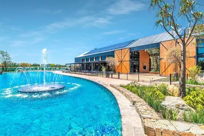 a swimming pool with a fountain in front of a building at The Lagoon Exquisite Apartments in Pretoria