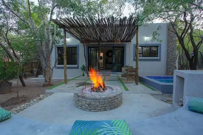 a fire pit in a yard in front of a house at EDJAMI Guest House in Marloth Park