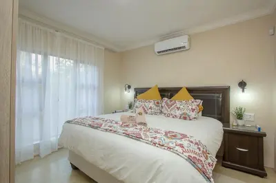 a bedroom with a large bed and a window at EDJAMI Guest House in Marloth Park