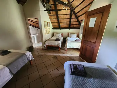 a bedroom with two beds in a room with a ceiling at Lama Lama Game Reserve in Mount Hope