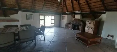 a living room with a table and a fireplace at Lama Lama Game Reserve in Mount Hope