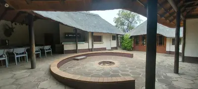 a building with a patio with a table and chairs at Lama Lama Game Reserve in Mount Hope