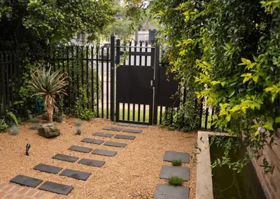 a garden with a fence and a gate with a pathway at Grace in Pretoria