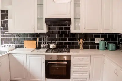 a kitchen with white cabinets and a stove top oven at Grace in Pretoria