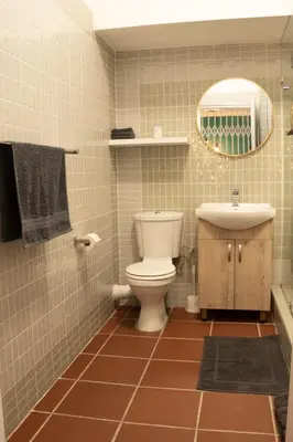 a bathroom with a toilet and a sink and a mirror at Grace in Pretoria