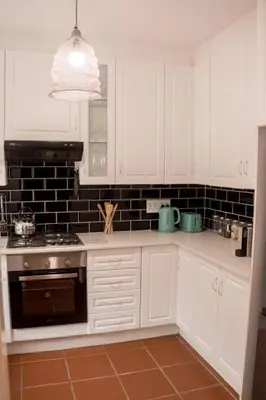 a kitchen with white cabinets and a stove top oven at Grace in Pretoria