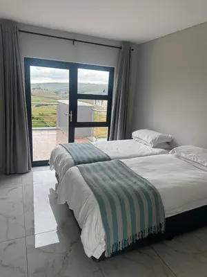 a bedroom with a large bed and a large window at 955 Highlands Gate Golf Estate in Dullstroom