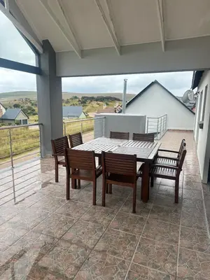 a patio with a table and chairs on a balcony at 955 Highlands Gate Golf Estate in Dullstroom
