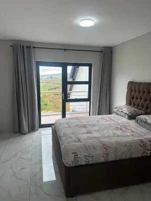 a bedroom with a large bed and a large window at 955 Highlands Gate Golf Estate in Dullstroom