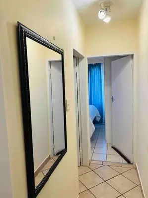 a mirror hanging on a wall in a hallway at Karabo Spaces in Midrand