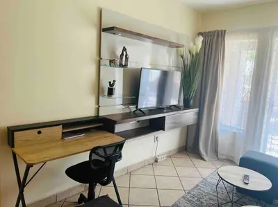 a desk with a computer in a room at Karabo Spaces in Midrand