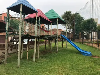 a playground with a blue slide in a park at Karabo Spaces in Midrand