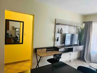 a living room with a desk and a mirror at Karabo Spaces in Midrand