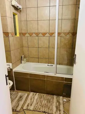 a bathroom with a tub and a toilet at Karabo Spaces in Midrand